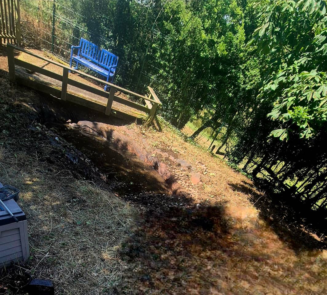 The old weathered timber boardwalk and worn pond edge at South Kilworth School before the work