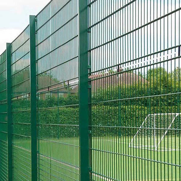 Green double-wire MUGA rebound fencing beside a sports pitch